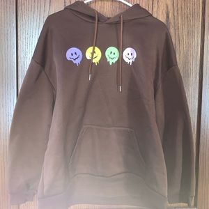 Brown hoodie with smiley faces on front.